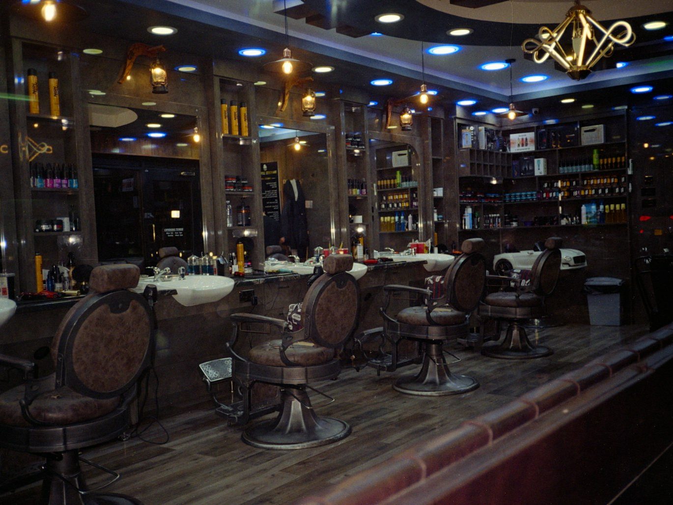 A barbershop interior with classic chairs and backlit shelves
