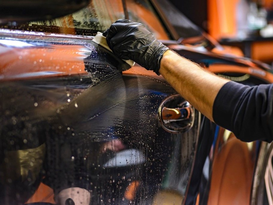 A car being hand-polished at a detailing bay