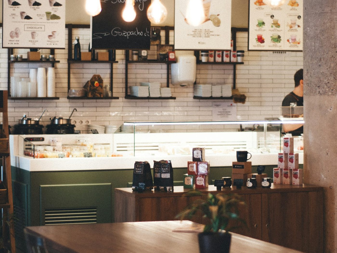 Inside a cafe — hanging bulbs over the counter where regulars order