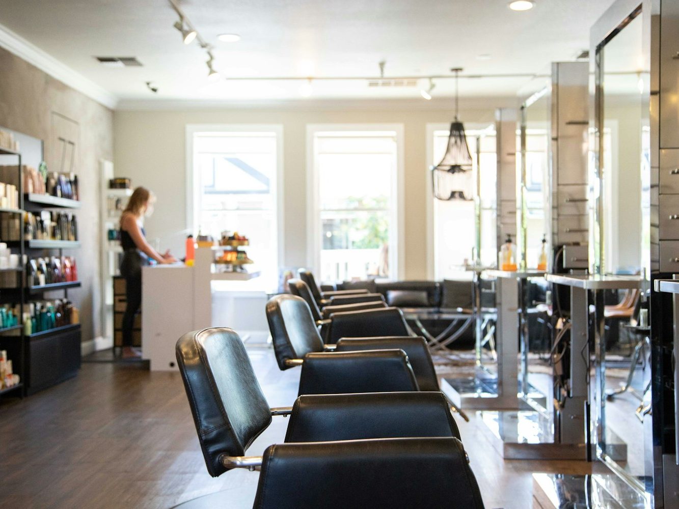 A bright hair salon floor with styling chairs and mirrors